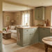 Rustic cottage interior with sage green kitchen, soft textiles, and warm natural light