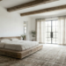 A wide-angle view of a serene sanctuary showcasing modern rustic bedroom ideas, featuring a low reclaimed oak platform bed, exposed ceiling beams, white lime-washed walls, and large steel-framed windows draping soft natural light onto a vintage wool rug.